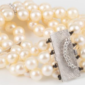 B240926 - 215: Pulsera de perlas cultivadas de tres vueltas con cierre y entrepiezas de oro y diamantes talla brillante. peso aprox. dts. 0.50ct.