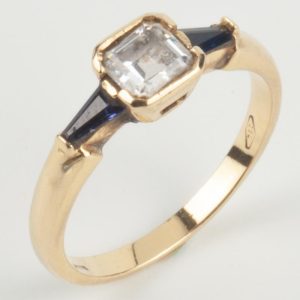 B241128 - 108: Sortija de oro con circonitas y piedras de color.