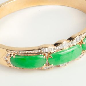 B250327 - 7: Brazalete de oro rigido con jade y diamantes talla trapecio y brillante. peso aprox. dts. 1.35ct.